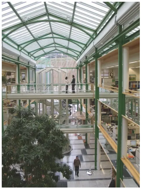 Ein dreistöckiges Atrium mit Glasdach, Verbindungsbrücken und Treppen