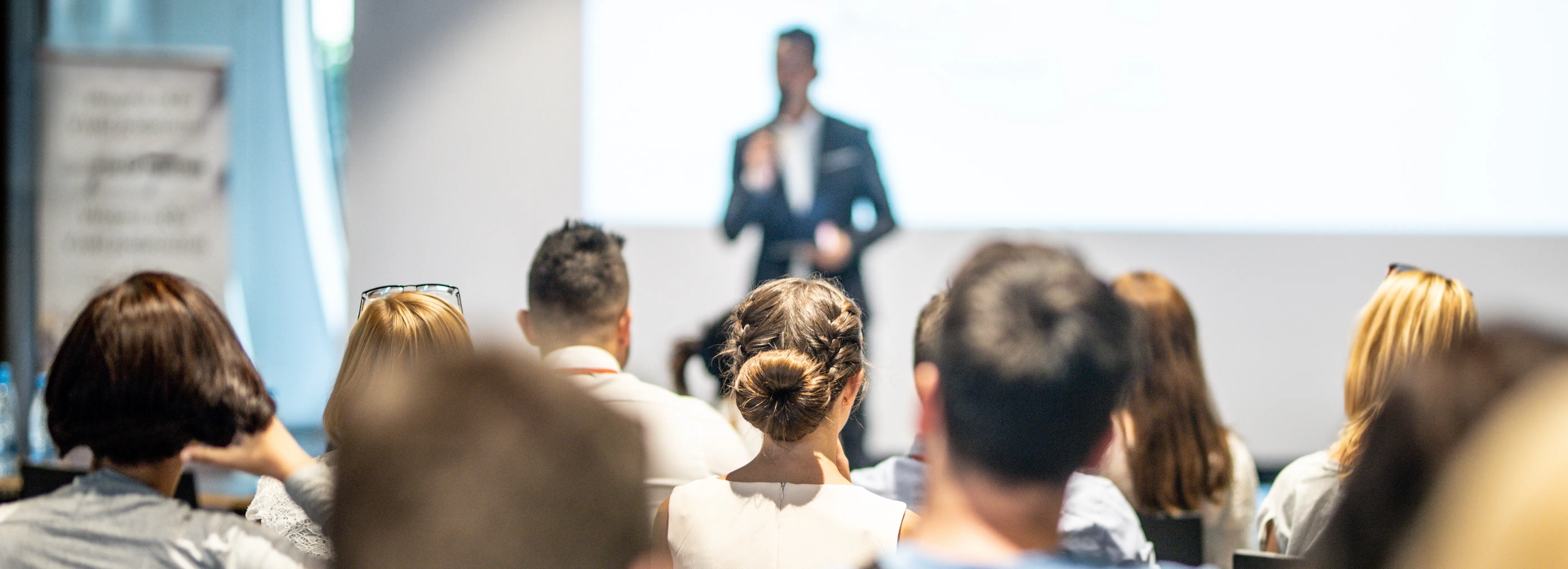 Male business speaker giving a talk at business conference event.