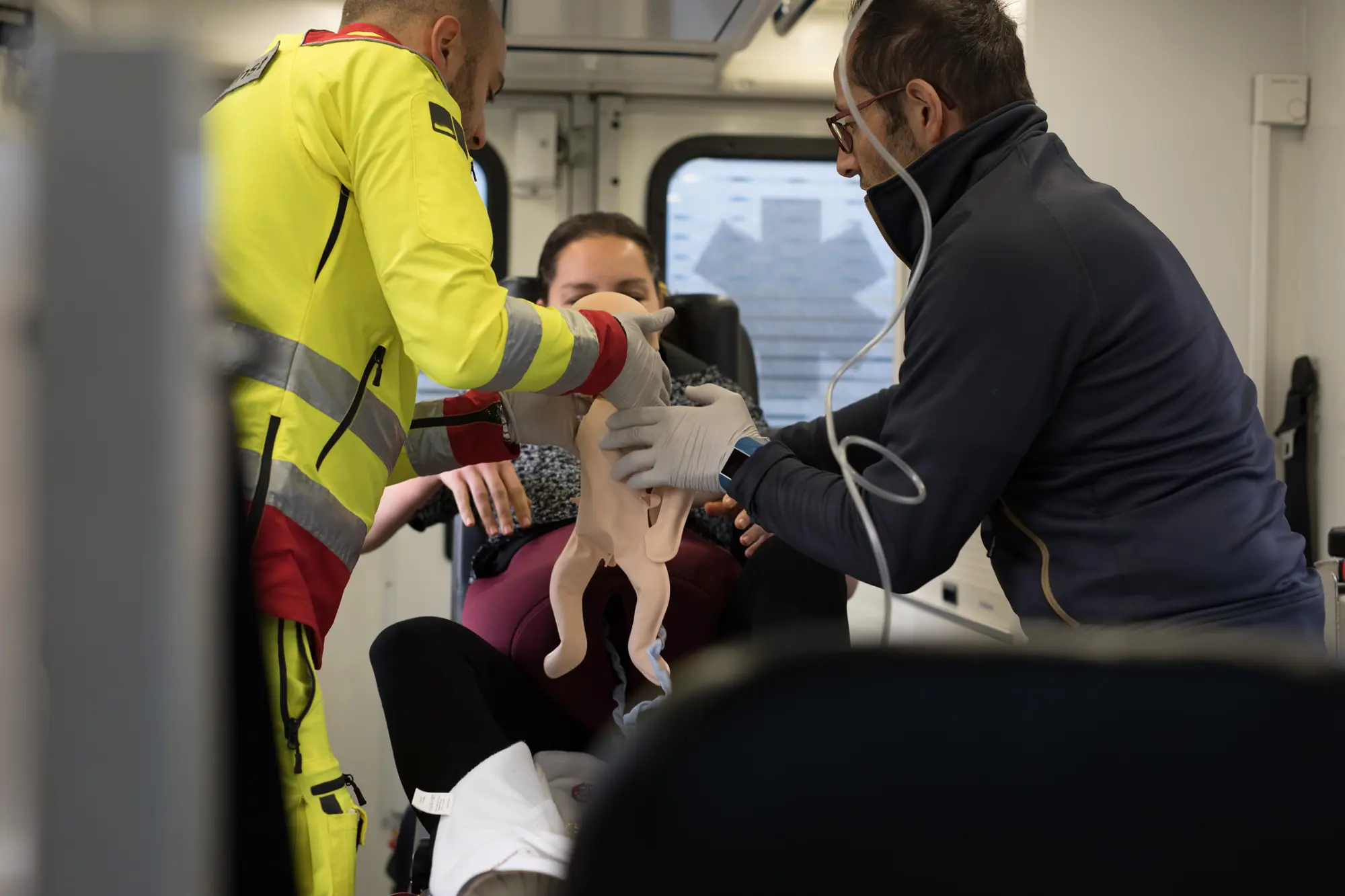 Die Sanitäter halten die Babypuppe in den Händen.